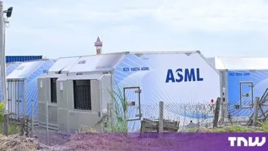 Large modular industrial containers featuring the blue ASML logo parked outdoors