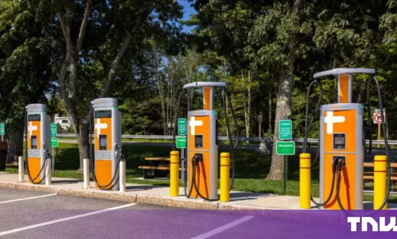 A row of four bright orange and silver ChargePoint electric vehicle chargers installed outdoors.