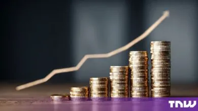 Stacks of gold coins increasing in height with a blurred financial growth chart in the background