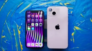 Front and back view of Apple iPhone 13 against vibrant blue background.