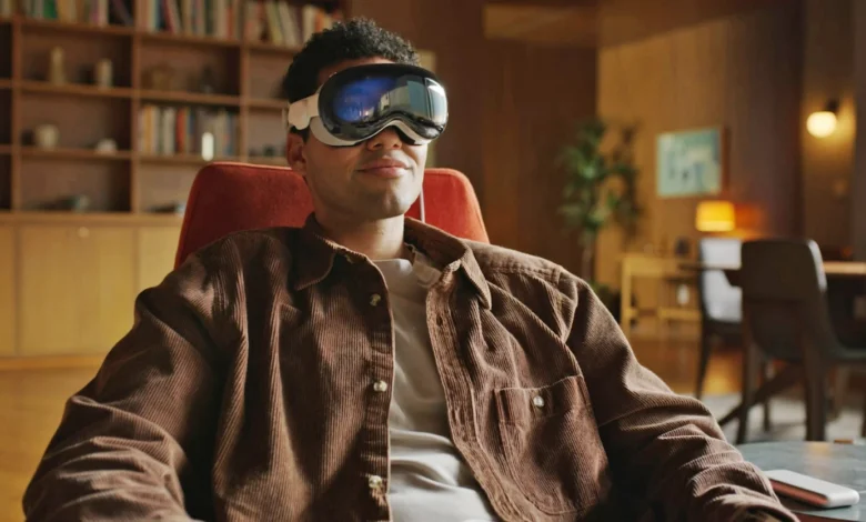 A man sitting on his couch wearing the Apple Vision Pro