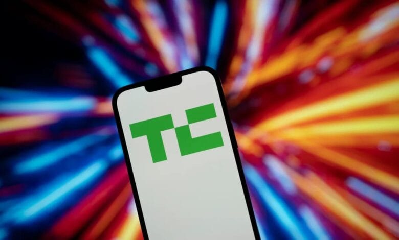 Smartphone displaying the TechCrunch logo, a green 'TC' in a square, against a vibrant, blurred background of multicolored streaks.