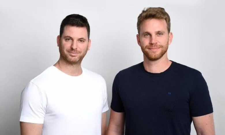 Yarden and Dor, stand shoulder-to-shoulder against a light gray background.