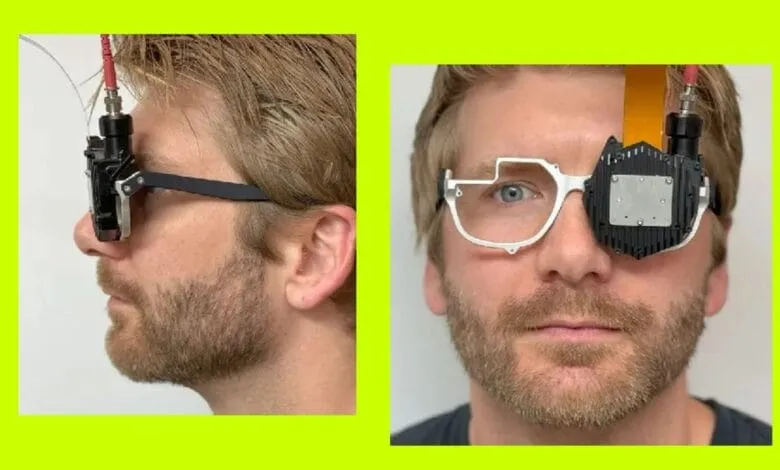 Close-up of a man wearing a prototype of glasses with an attached device over one eye.