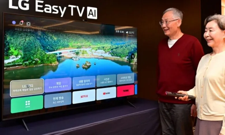 Elderly couple smiles while looking at an LG Easy TV AI screen displaying a scenic landscape and app icons.