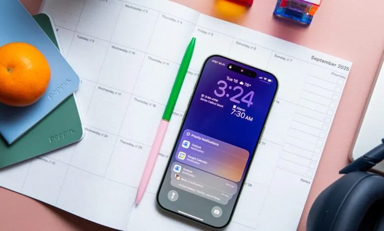 iPhone displaying notifications on a calendar, alongside stationery and headphones.