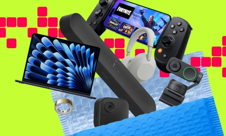 Assortment of tech gadgets, including a laptop, soundbar, headphones, and gaming accessories, spilling from a blue padded envelope.