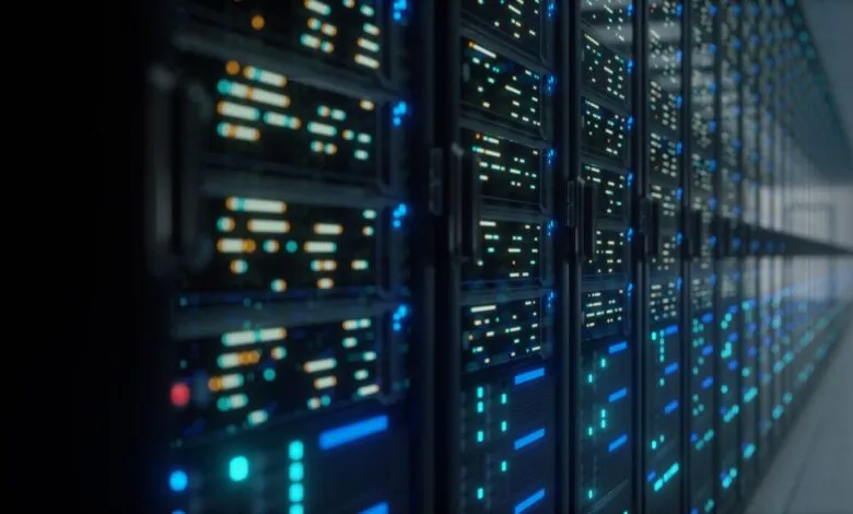 Rows of illuminated server racks in a data center, glowing with blue and orange lights.