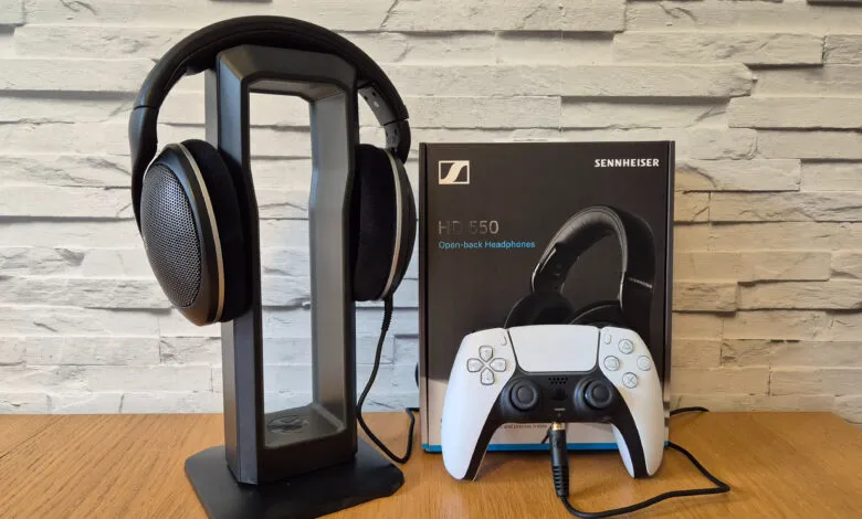 Sennheiser HD 550 headphones on a stand next to a PS5 controller and box.
