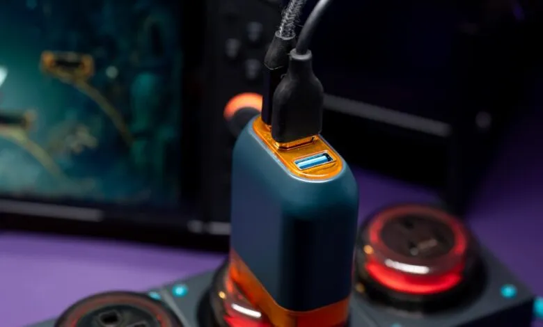 Close-up of a blue and orange USB charger plugged into a power strip, with cables connected.