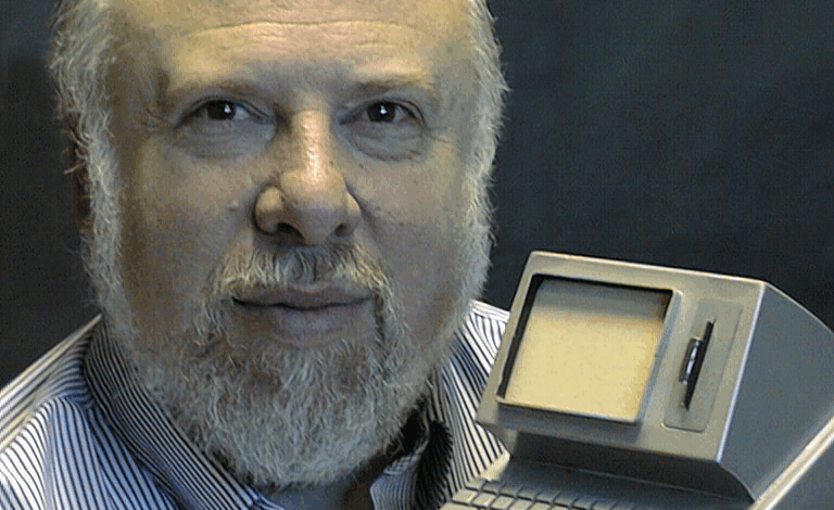 Jaron Lanier, computer scientist, holds a small, early personal computer.