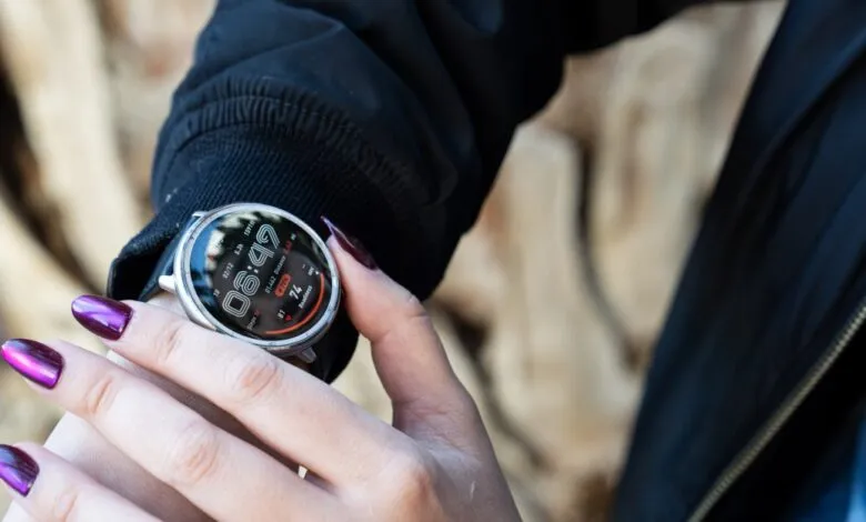 Close-up of a person's hand with purple nail polish checking a smartwatch.