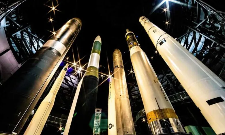 A collection of large rockets displayed vertically in a museum setting.