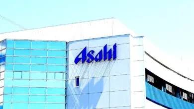 The blue Asahi logo is prominently displayed on the side of a modern white building with blue glass windows.