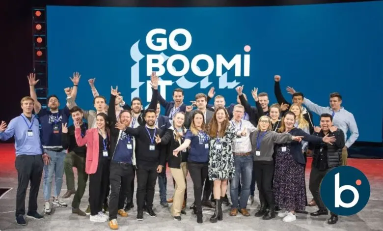 A diverse group of people posing for a photo with their hands raised in excitement.