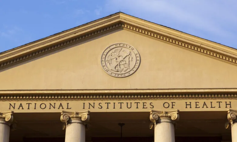 Close-up of the National Institutes of Health building facade with columns and seal.
