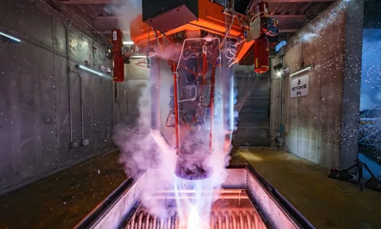 Rocket engine test firing with intense blue and purple flames and white smoke.