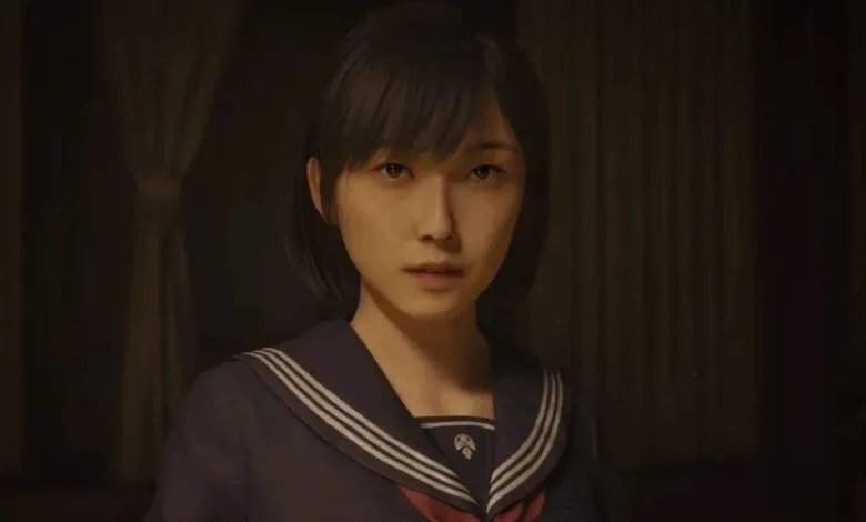 Close-up of a young woman with short black hair wearing a dark sailor uniform.