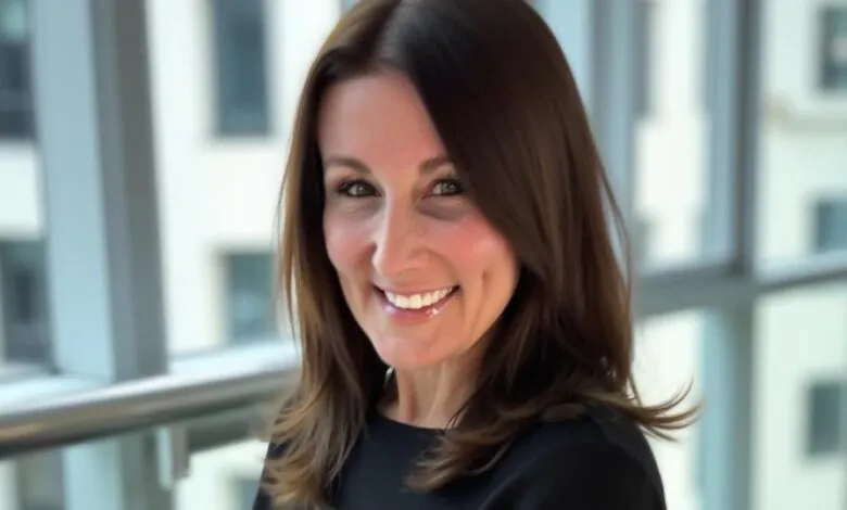 Portrait of Amanda Kahlow smiling, with a blurred office building background.