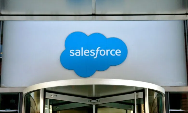 Salesforce logo on a building facade above a revolving glass door.