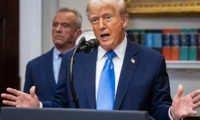 Donald Trump speaks at a podium with Robert F. Kennedy Jr. behind him.