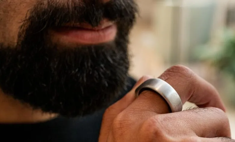 Close-up of a man's hand wearing a sleek, silver smart ring.