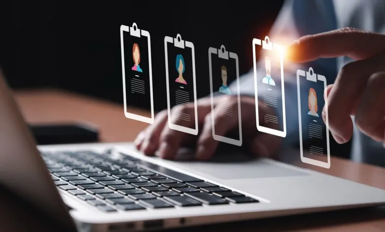 Person selecting a profile from a digital list on a laptop screen.