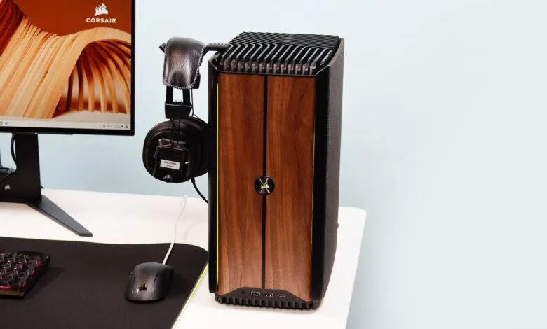 Corsair PC tower with headphones, keyboard, mouse, and monitor on a white desk.