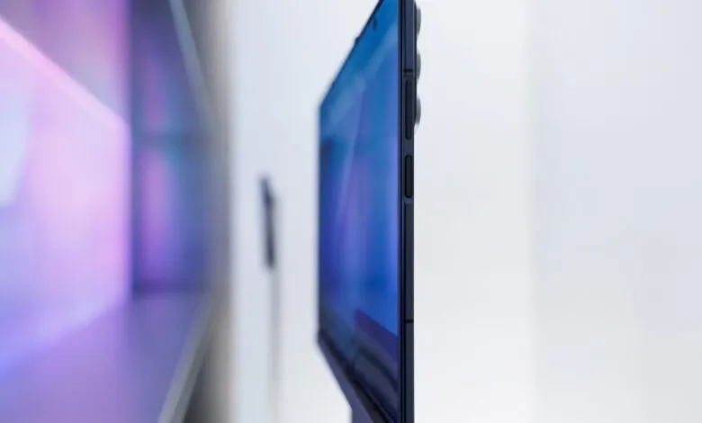 Close-up side view of a dark blue smartphone with buttons on the edge.