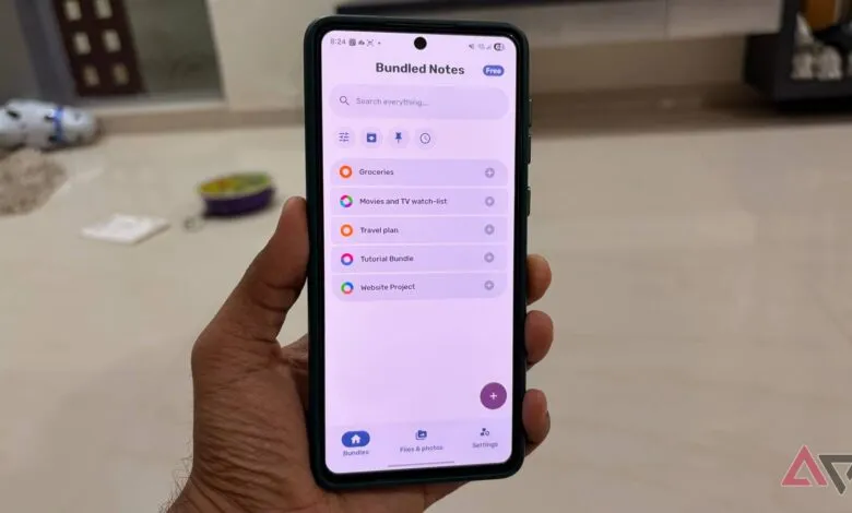 Person holding a smartphone displaying the Bundled Notes app with various lists.