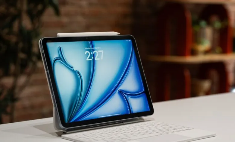 iPad Air with keyboard and pencil on a white surface.