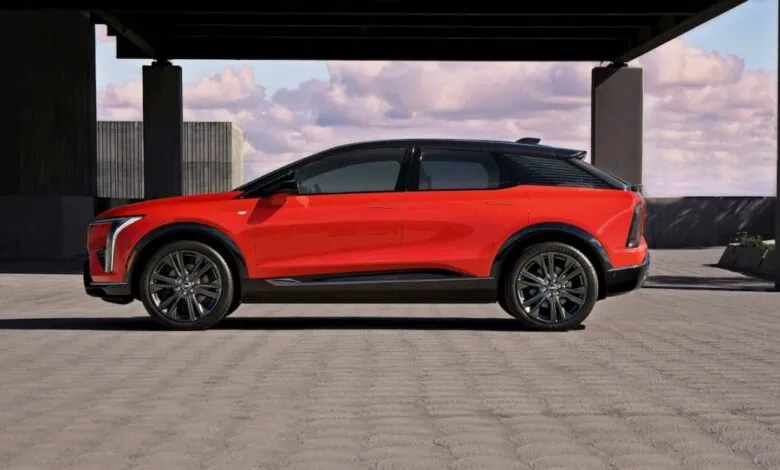 Red Cadillac LYRIQ electric SUV parked in modern setting.