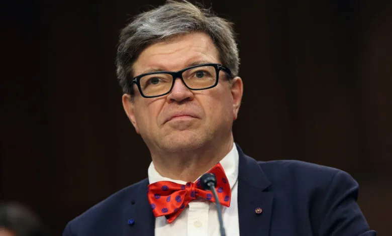 Jeffrey Sachs testifies wearing a red bow tie and glasses.