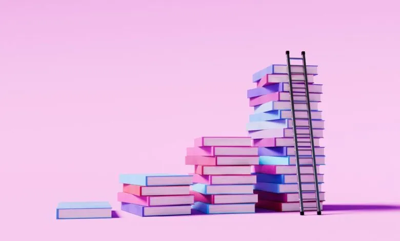 Stacks of colorful books form steps with ladder on pink background.