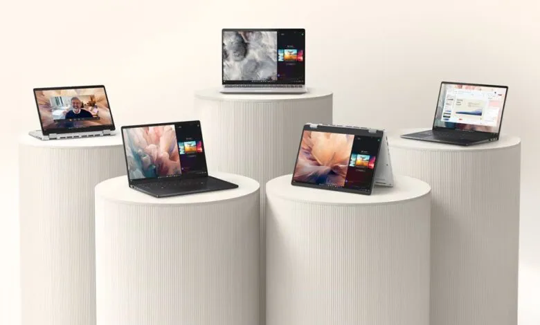 Five laptops displayed on white pedestals against a neutral background.