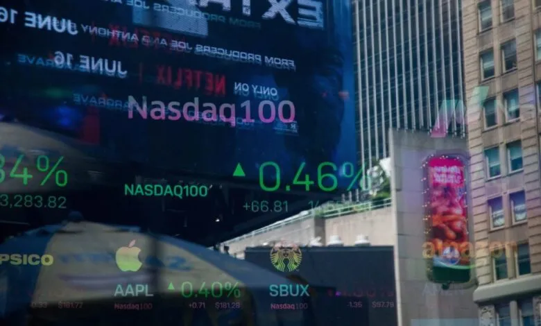 Reflections of stock market data and company logos on a building facade.