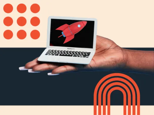 Hand holds a miniature laptop displaying a red rocket, symbolizing startup success.
