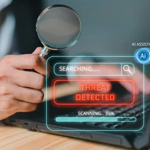 Threat detected on laptop screen, magnified by a hand holding a magnifying glass.