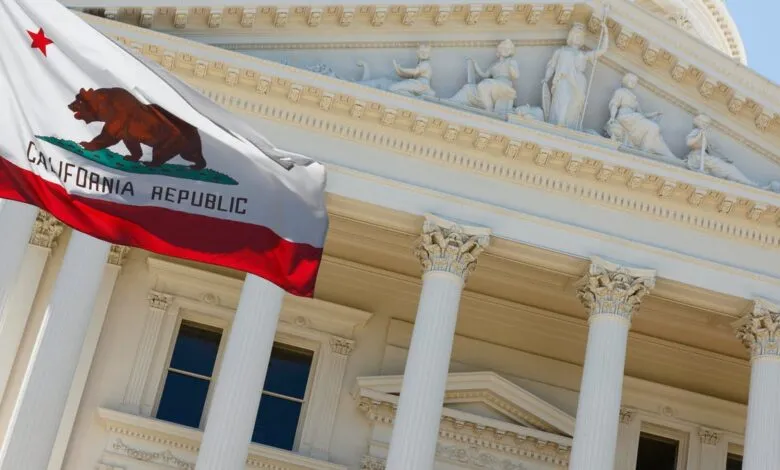 California state flag waving in front of the Capitol building.