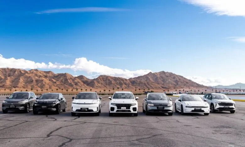 Lineup of Geely Auto Group vehicles on a cracked asphalt surface.