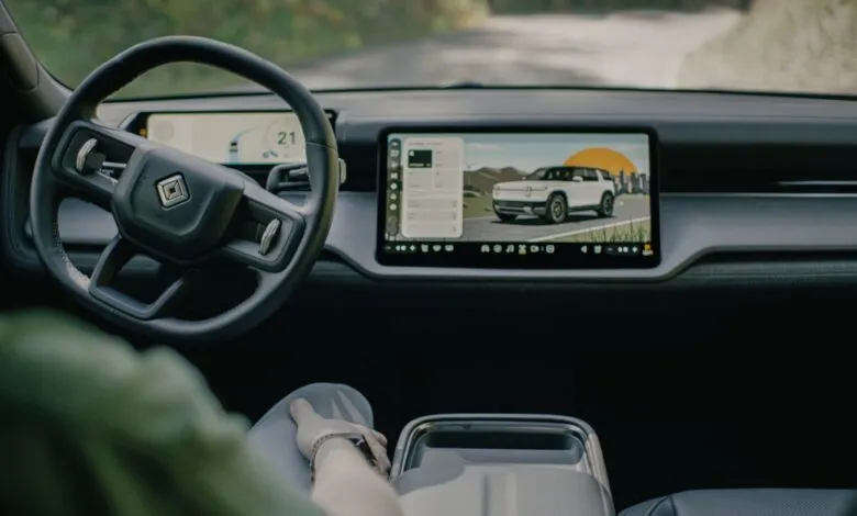 Rivian R2 interior view showing dashboard screen and steering wheel.