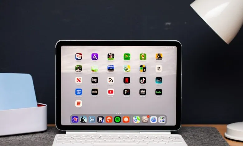 iPad Air on desk with keyboard, showing app icons on the screen.