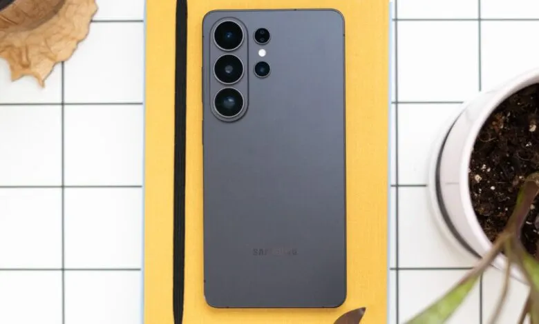 Samsung Galaxy S23 Ultra on yellow notebook, surrounded by plants.