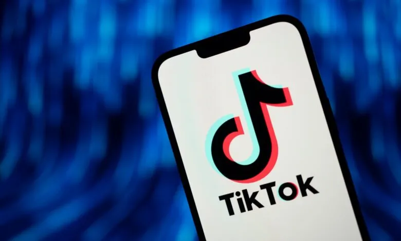 TikTok logo displayed on a smartphone screen against a blue background.