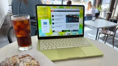 Lime green MacBook on table with iced tea and pastry, cafe setting.