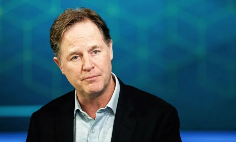 Portrait of Nick Clegg against a blue geometric background.