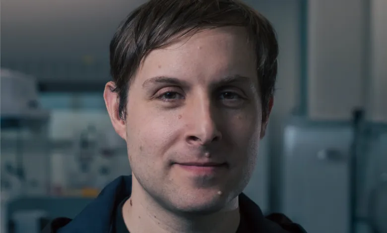 Headshot of a man with brown hair and a slight smile, looking directly at the camera.