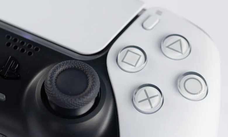 Close-up of a white and black PlayStation 5 DualSense controller.