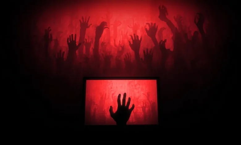 Silhouetted hands reach from a red screen, evoking a horror movie scene.