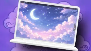 Laptop displays dreamy night sky with moon and shooting stars.